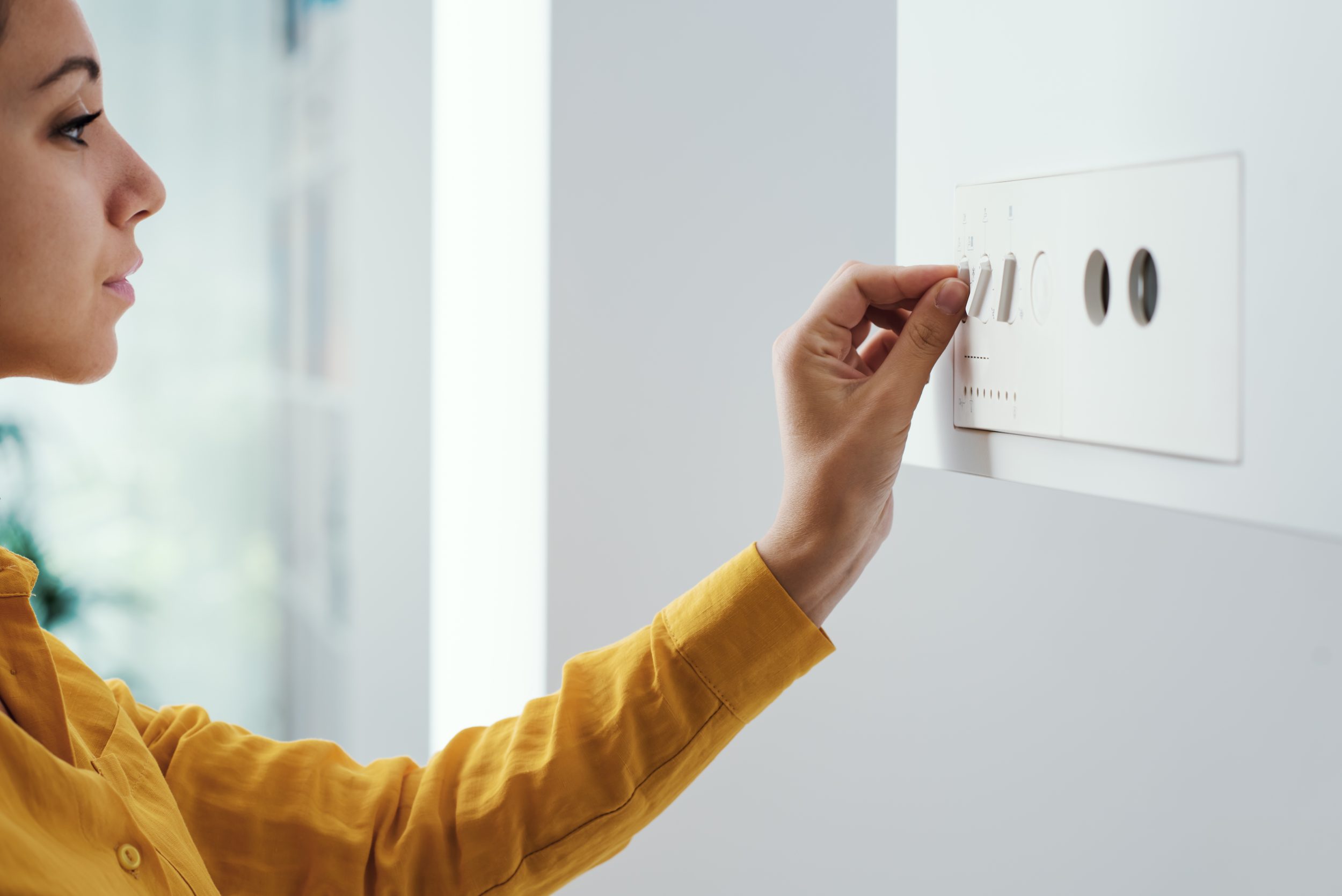 woman adjusting dials on boiler