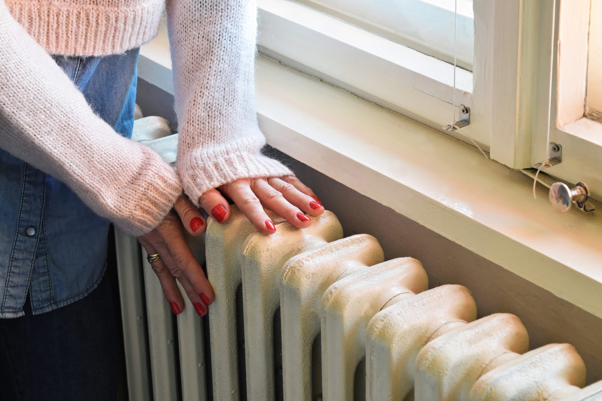 woman with hands on a radiator