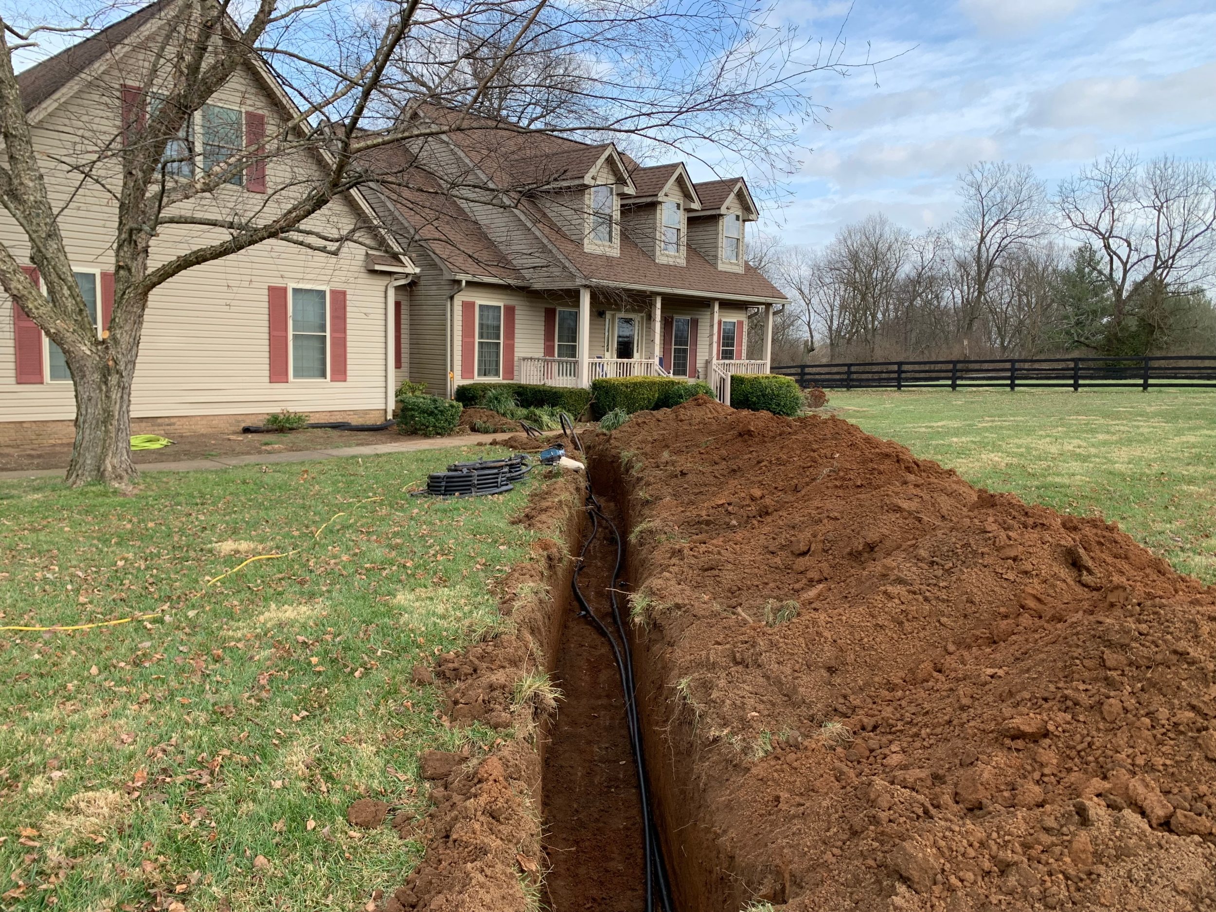 Furrow dug in the ground outside a house for the installation of a heat pump.